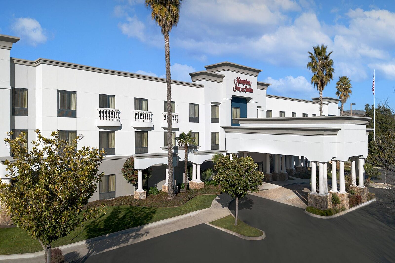 Hampton Inn & Suites Paso Robles exterior with palm-lined entrance on a sunny day